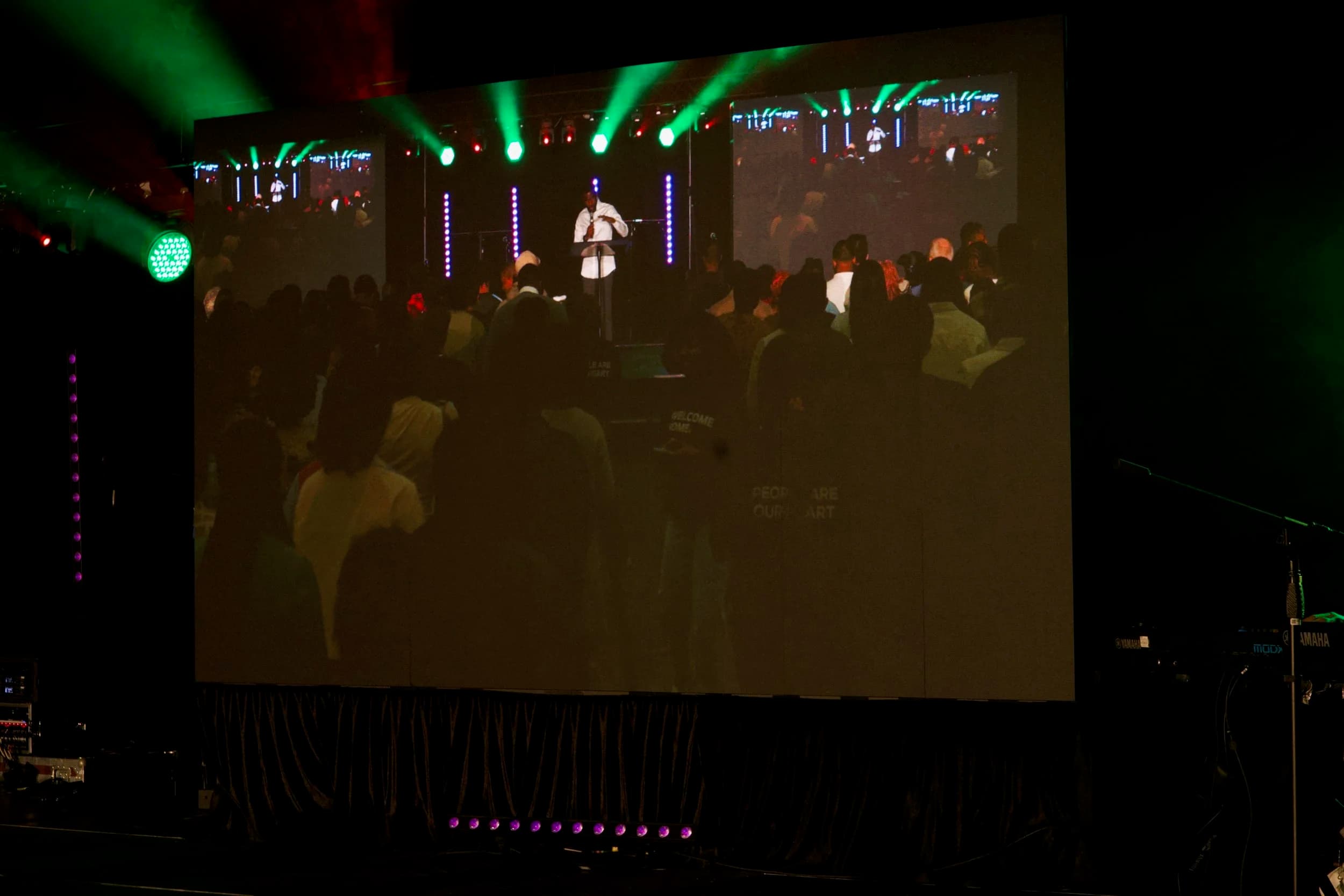 Audience silhouettes in front of an IMAG LED wall during an Ottawa live event