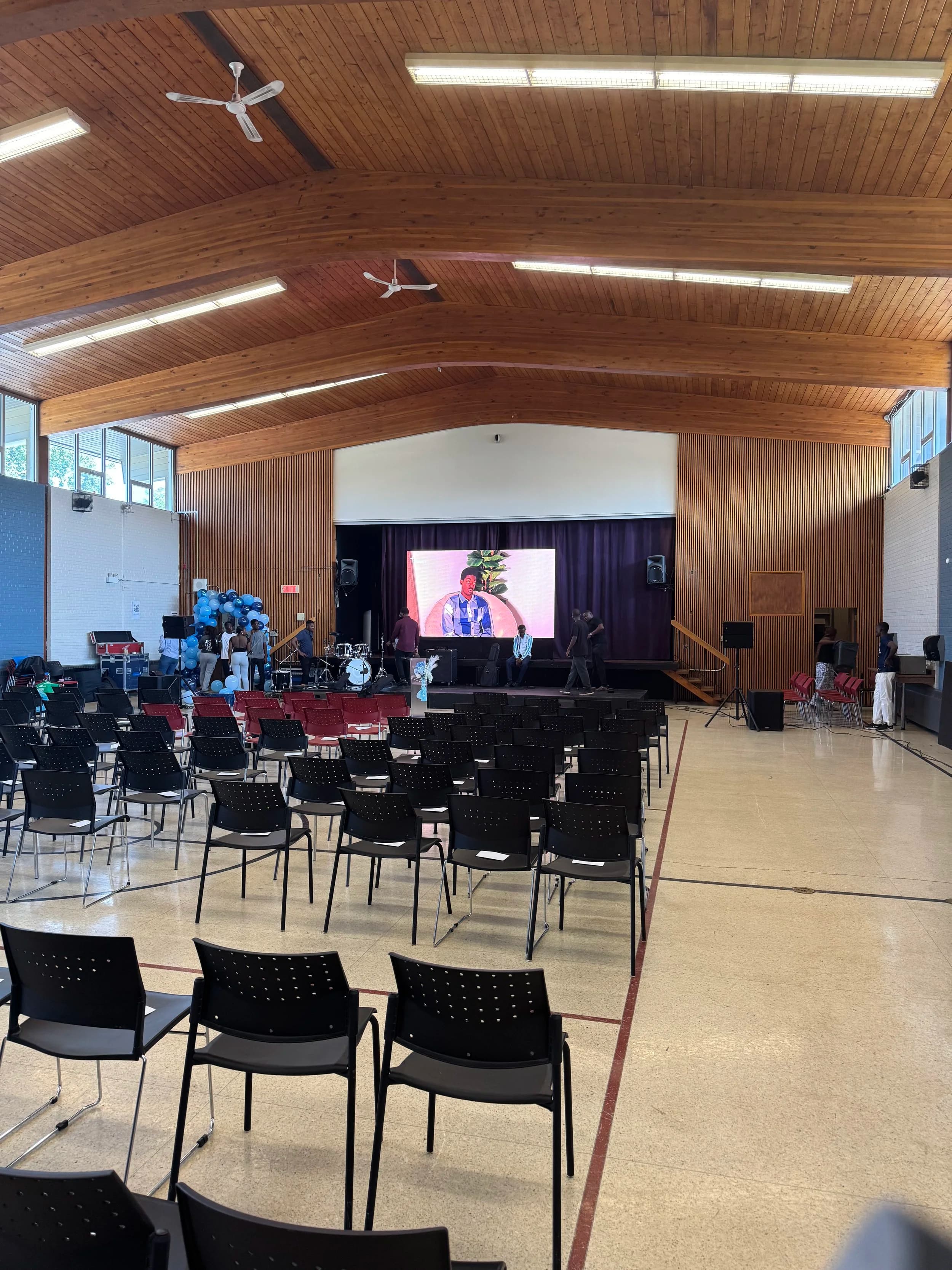LED wall on stage at an Ottawa community hall with a vaulted wood ceiling