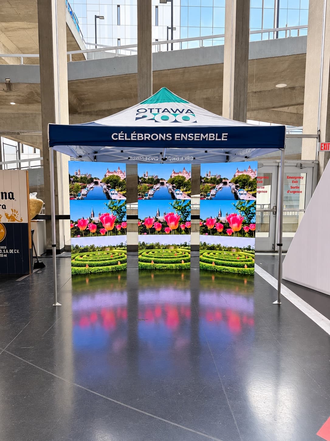 Three freestanding LED poster displays side by side under an Ottawa 200 event tent